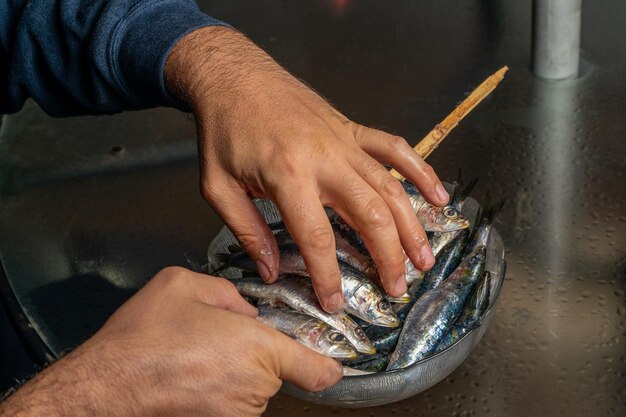 Photo cropped hand of man holding fishes in bowl