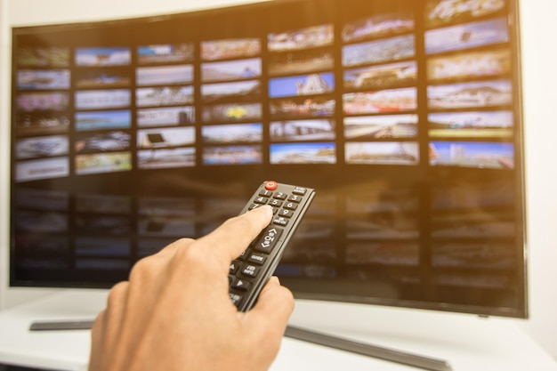 Photo cropped hand of man holding remote control at home