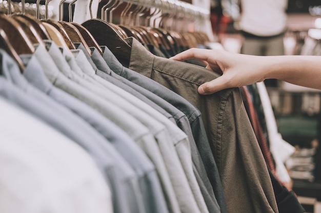 Photo cropped hand of man holding shirt in shop