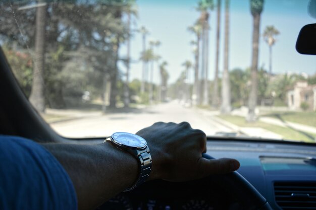 Photo cropped hand of man holding steering wheel in car