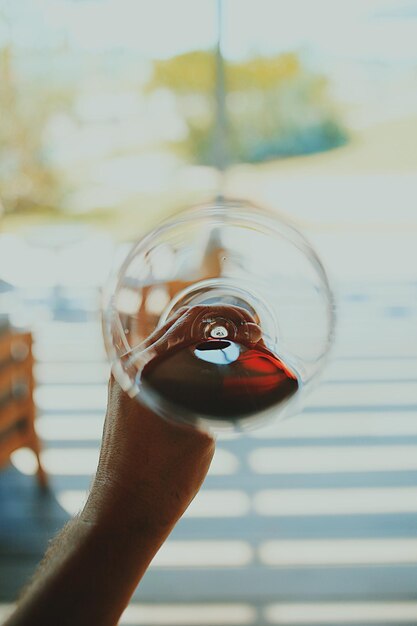 Foto mano tagliata di un uomo che tiene un bicchiere di vino