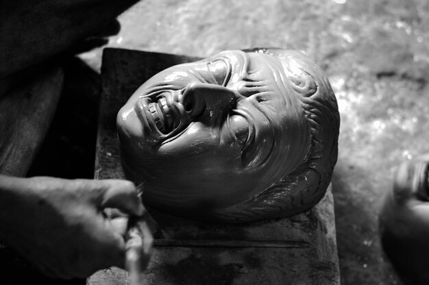 Photo cropped hand of man making sculpture in workshop