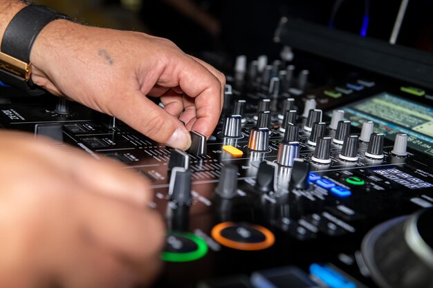 Foto la mano tagliata di un uomo sulla tavola di mixaggio del dj di festa