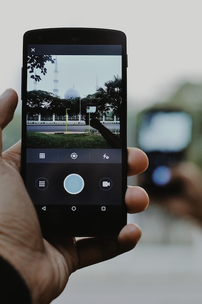 Photo cropped hand of man photographing through mobile phone