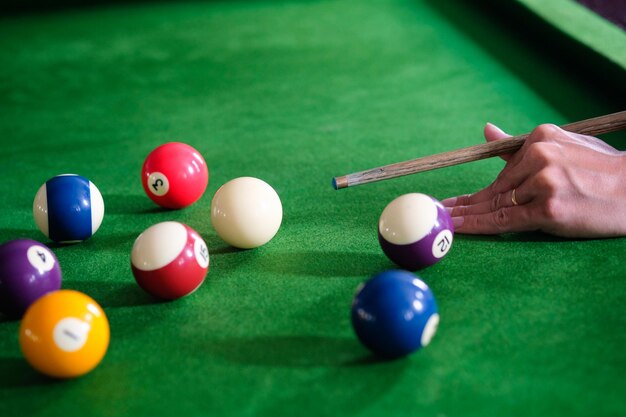 Photo cropped hand of man playing pool at club