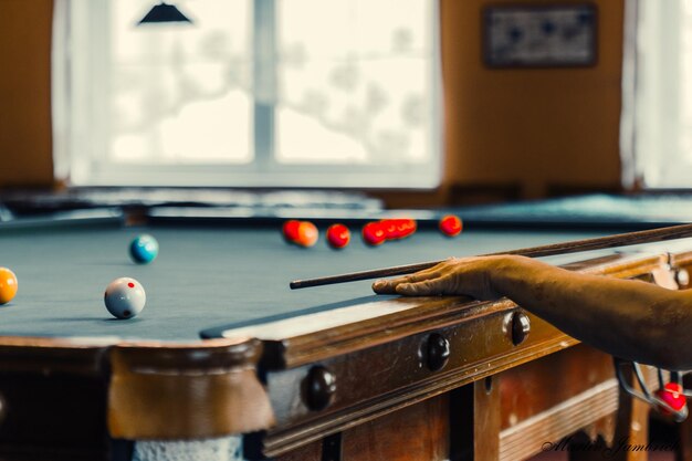 Photo cropped hand of man playing pool in room