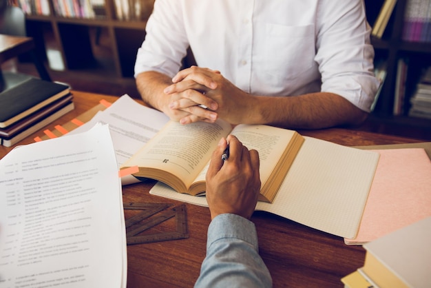 Foto mano tagliata di un uomo che indica un libro