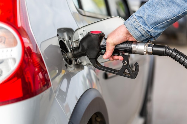 Cropped hand of man refueling car