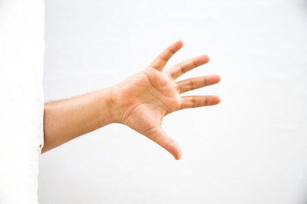 Photo cropped hand of man showing stop gesture against wall