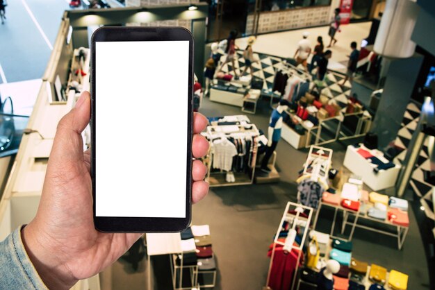 Photo cropped hand of man using smart phone in clothing store