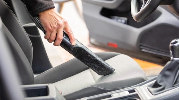 Photo cropped hand of man vacuuming car