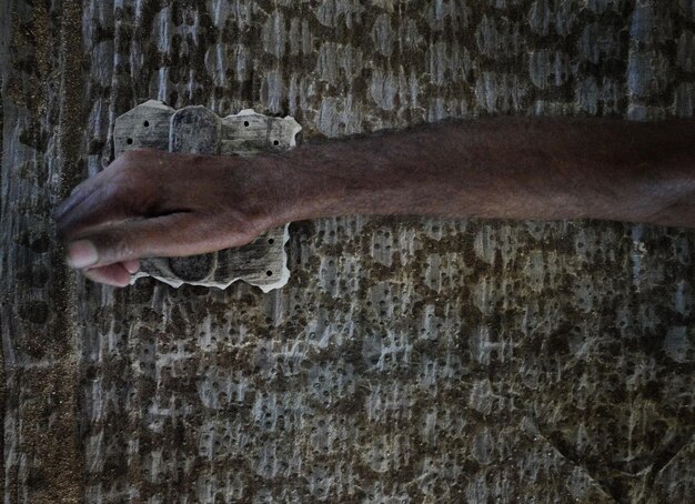 Foto mano tagliata di un uomo che lavora in officina