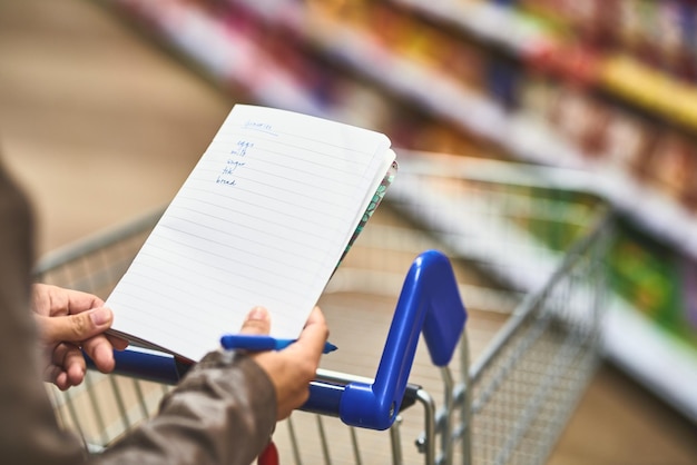 Foto mano tagliata di un uomo che scrive in un libro