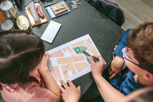 Foto mano tagliata di una madre che mostra una mappa ai bambini