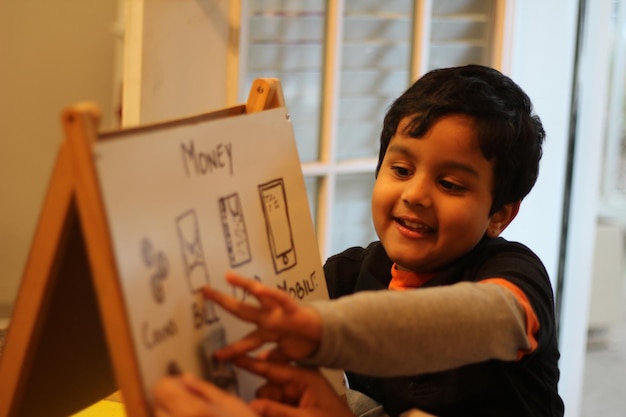 cropped hand of mother teaching son on whiteboard