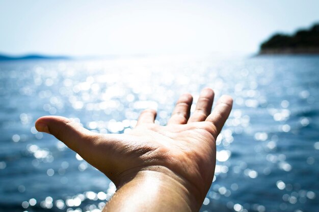 写真 空と対峙する海を越えて人間の手を切り取った