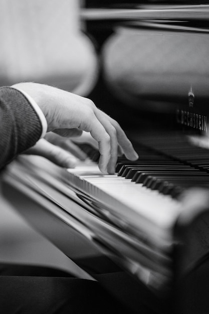 Фото Обрезка руки человека, играющего на пианино.