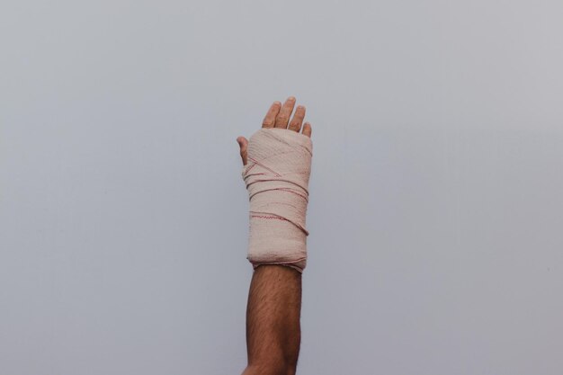 Фото Отрезанная рука человека, обернутая повязкой на белом фоне