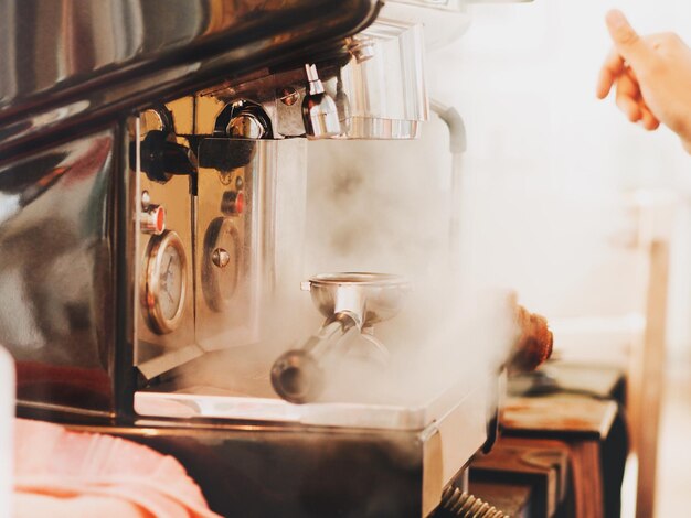 写真 カフェのエスプレッソメーカーから放出される蒸気によって切断された人の手