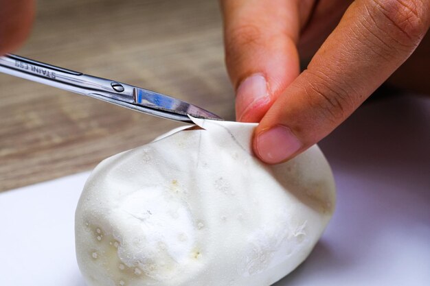 写真 テーブルの上で食べ物を切る人の手を切った