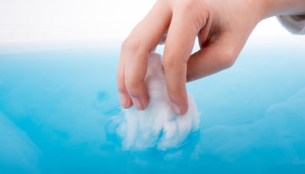 Фото Отрезанная рука человека, промывающего хлопок в голубой воде