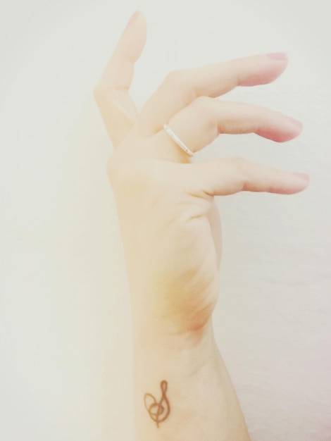 사진 ⁇ 색 배경 에 문신 을 한 여자 의 절단 된 손