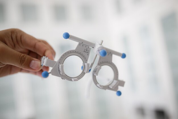 Photo cropped hand of ophthalmologist holding eye test equipment in medical clinic