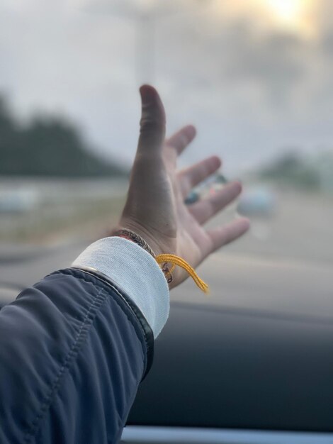 Photo cropped hand of person by window in car