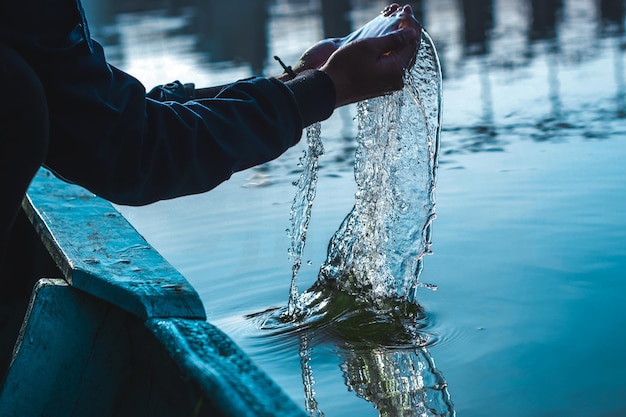 Foto mano tagliata di una persona che raccoglie acqua in mare