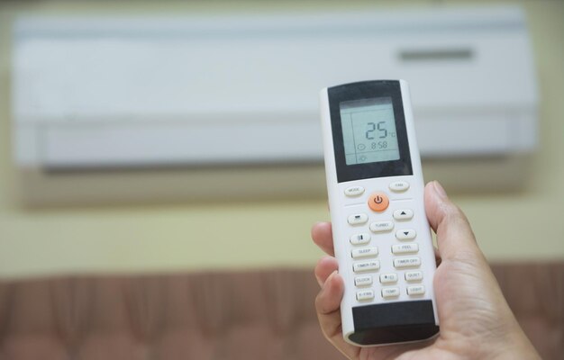 Photo cropped hand of person holding air conditioner remote