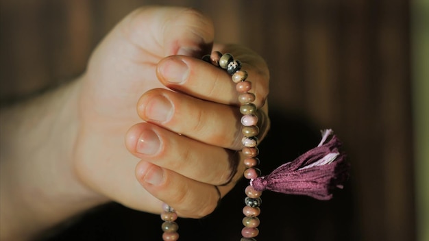 Foto mano tagliata di una persona che tiene una collana di perle