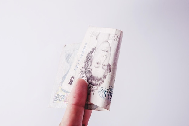 Photo cropped hand of person holding british currency against white background