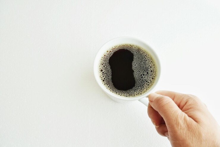 Photo cropped hand of person holding coffee against white background