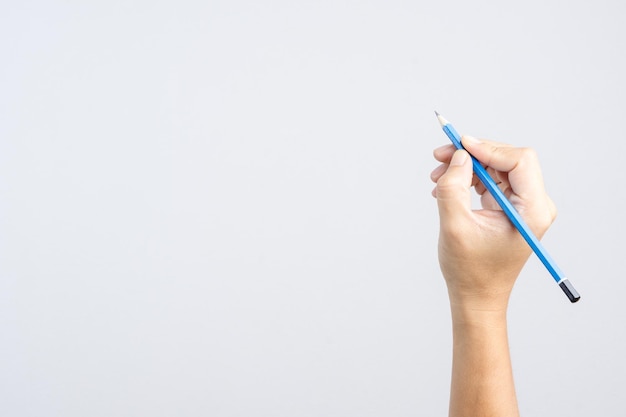 Photo cropped hand of person holding pencil against gray background