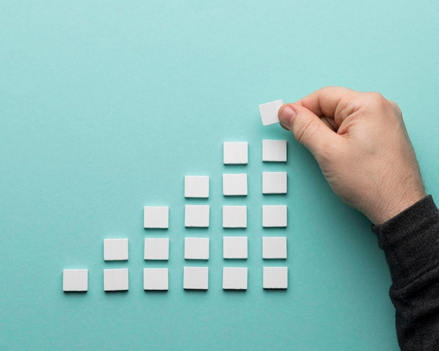 Photo cropped hand of person holding toy blocks on blue background