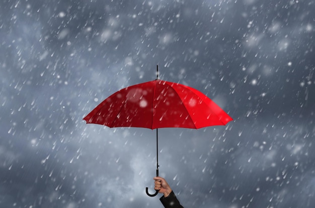 Cropped hand of person holding umbrella during rainy season