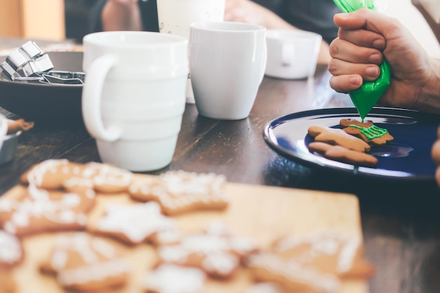 Foto mano tagliata di una persona che fa i biscotti sul tavolo