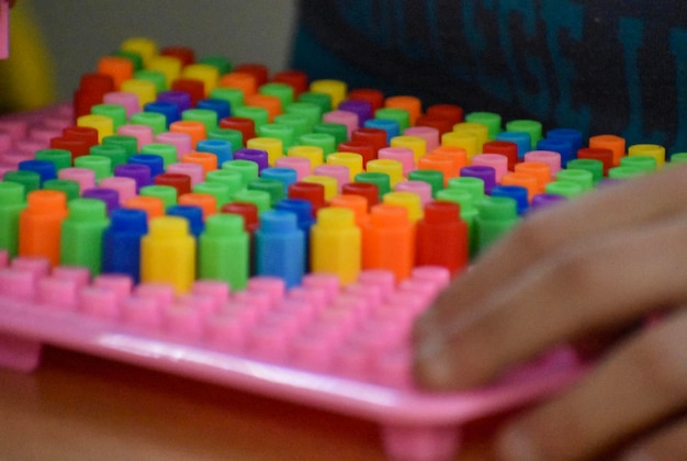Foto mano tagliata di una persona che gioca con giocattoli multicolori
