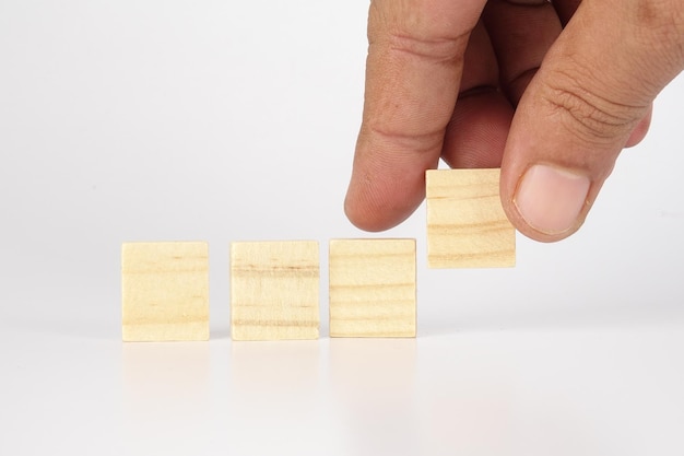 cropped hand of person playing with toy blocks over white background