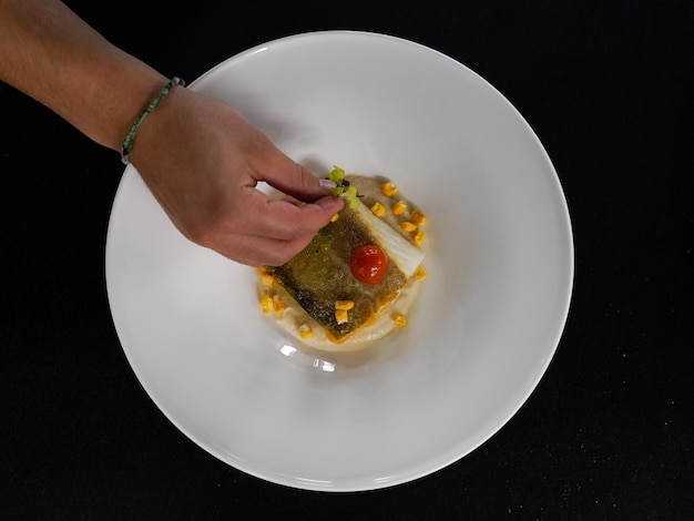 Photo cropped hand of person preparing food in plate