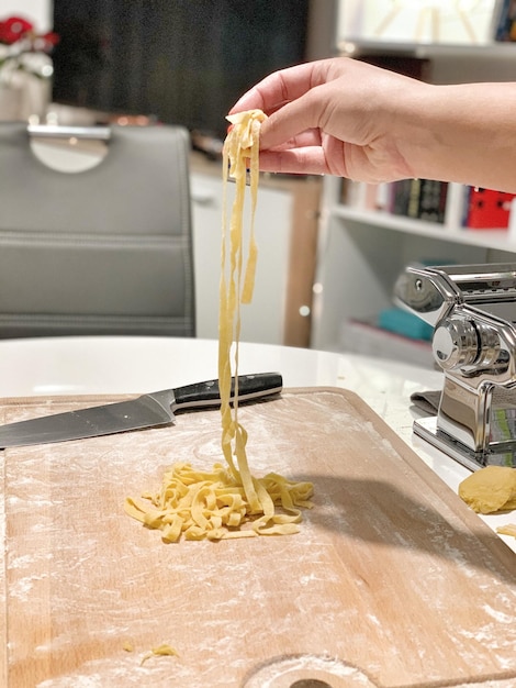 Foto mano tagliata di una persona che prepara il cibo su tavola