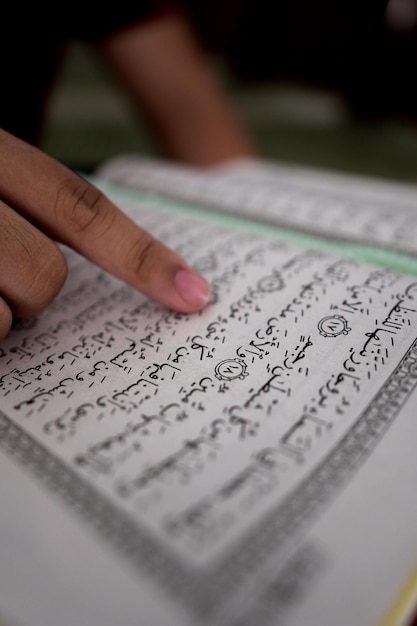 Foto mano tagliata di una persona che legge un libro sacro