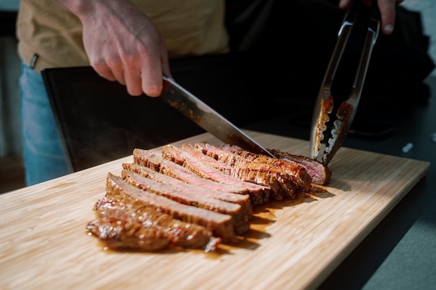 Photo cropped hand of person slicing meat on table