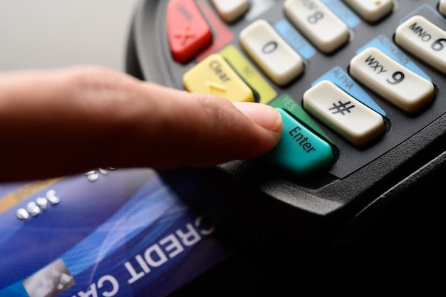 Photo cropped hand of person using credit card reader on table