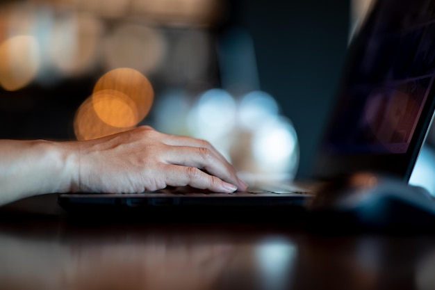 Cropped hand of person using laptop on table