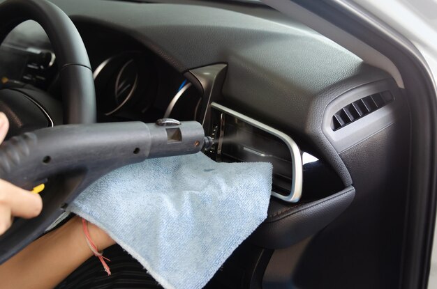 Photo cropped hand of person with cleaning equipment in car