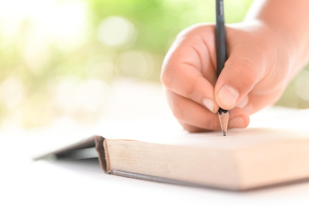 Foto mano tagliata di una persona che scrive in un libro