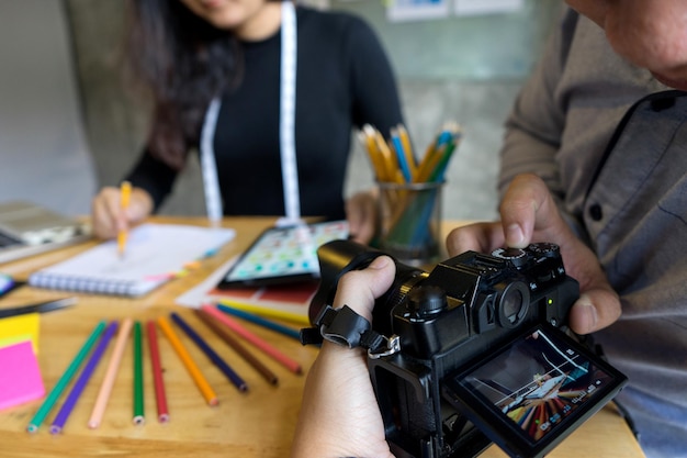 Foto mani tagliate che fotografano un designer di moda che lavora alla scrivania