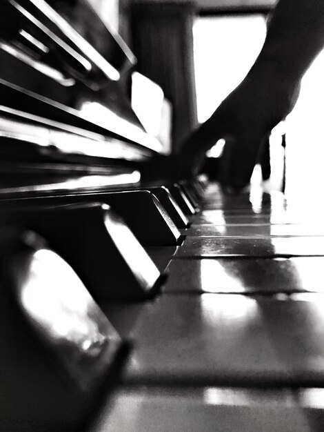 Foto mano tagliata che suona il pianoforte a casa