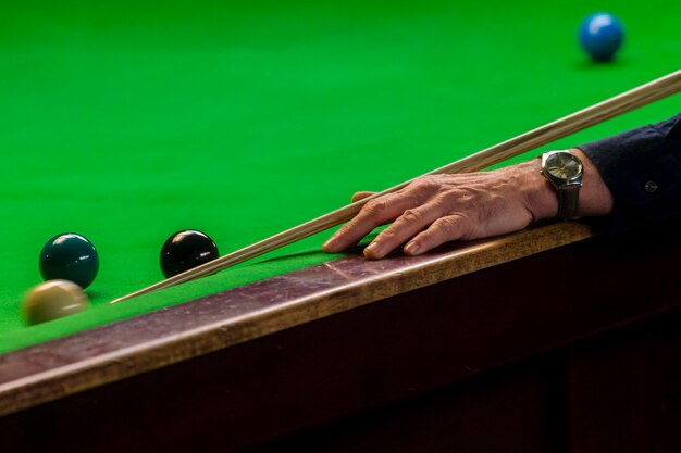 Cropped hand playing pool on table